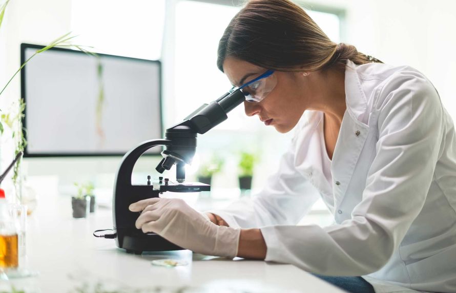 Une femme regardant dasn un microscope